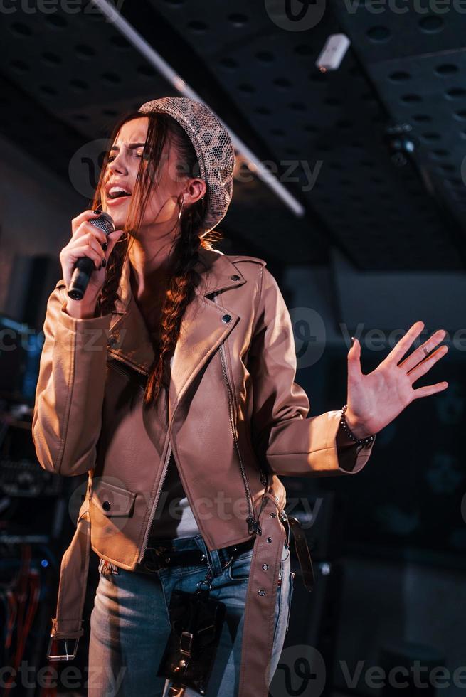 Young beautiful female performer rehearsing in a recording studio photo