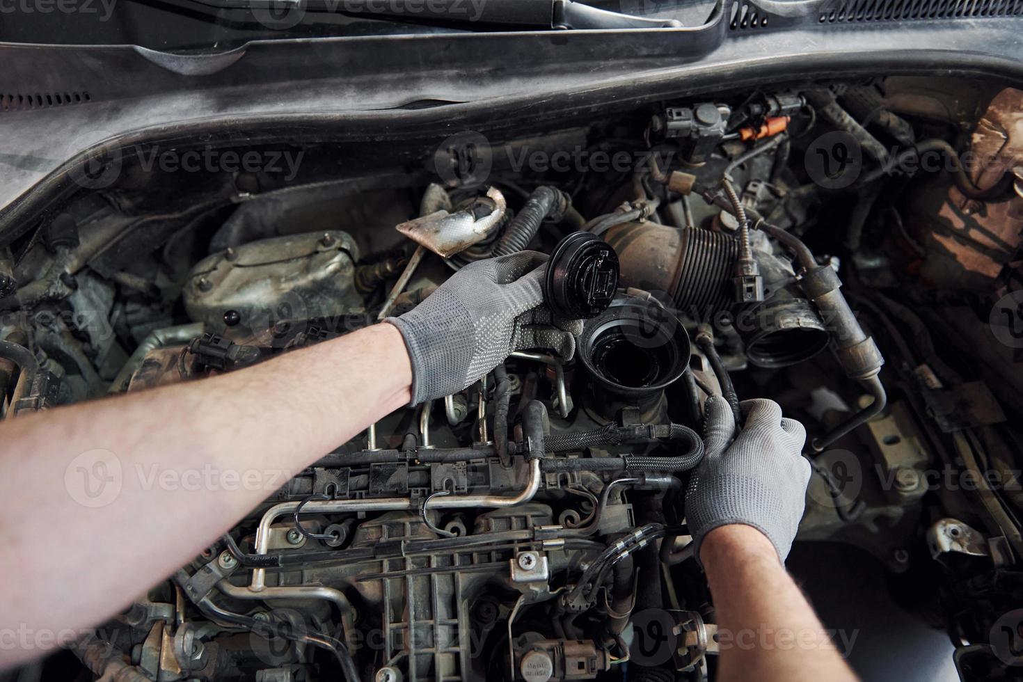 First person view of man's hands that repairs automobile. Conception of automobile service photo