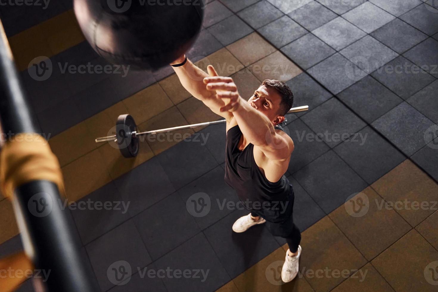 Strong man in sportive clothes playing basketball in the gym photo