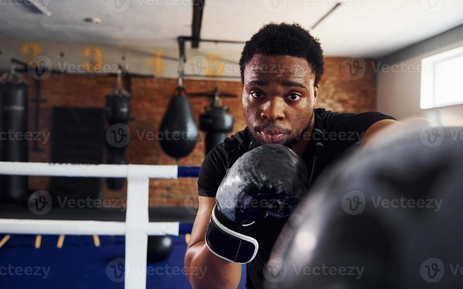 Strong african american boxer in sportive clothes have practice in the gym photo
