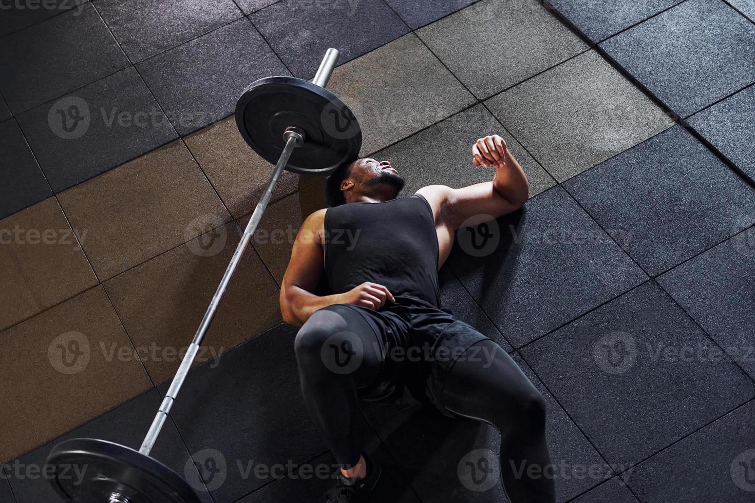 Taking a break. Strong african american man in sportive clothes have workout day in the gym photo