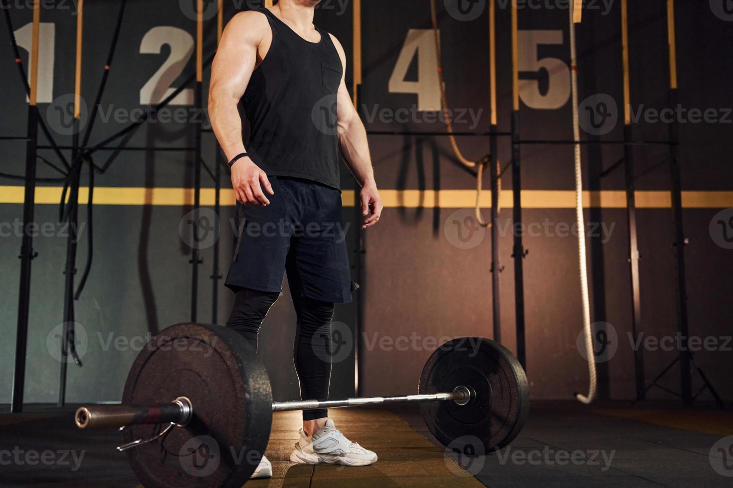 hombre fuerte con ropa deportiva levantando pesas en el gimnasio foto