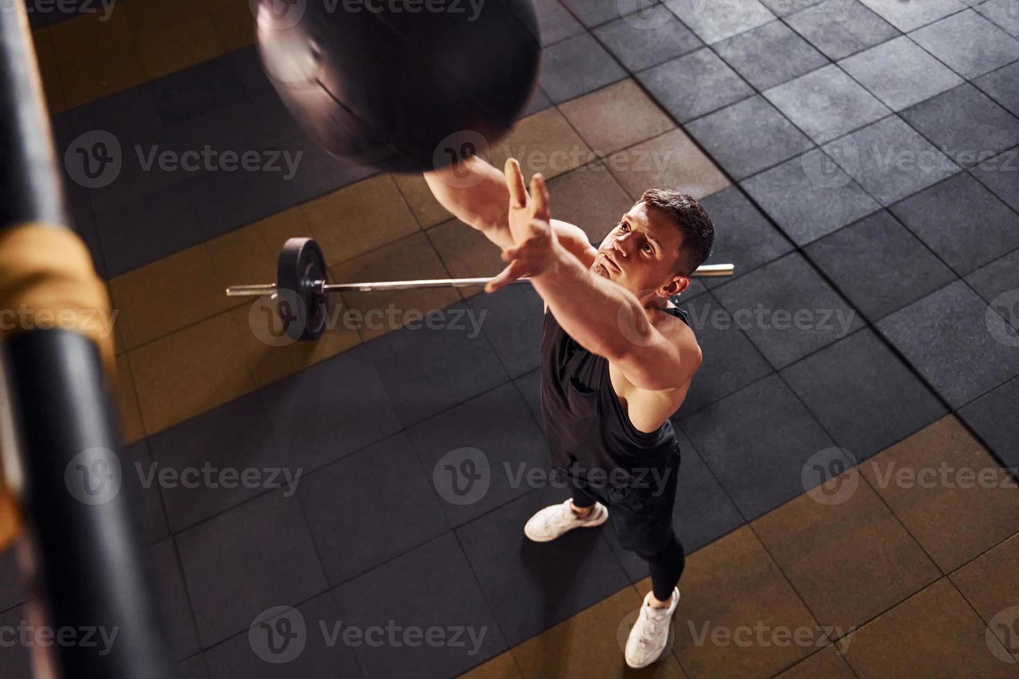Strong man in sportive clothes playing basketball in the gym photo