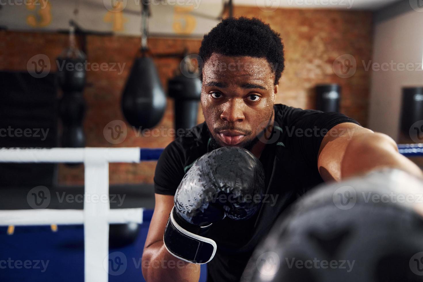 Strong african american boxer in sportive clothes have practice in the gym photo