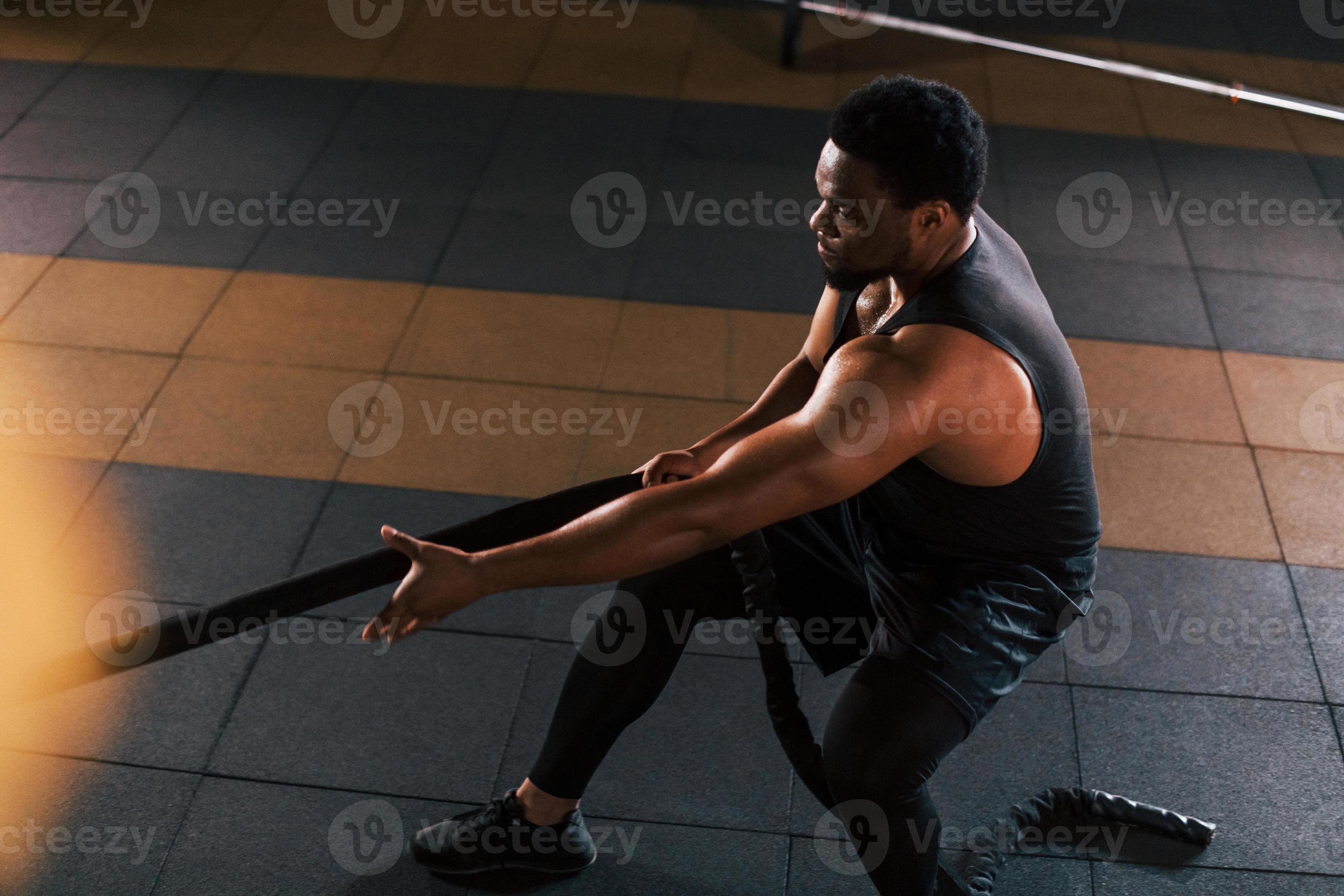 un hombre afroamericano fuerte con ropa deportiva tiene un día de  entrenamiento en el gimnasio. haciendo crossfit usando cuerdas 15293887  Foto de stock en Vecteezy, crossfit hombre