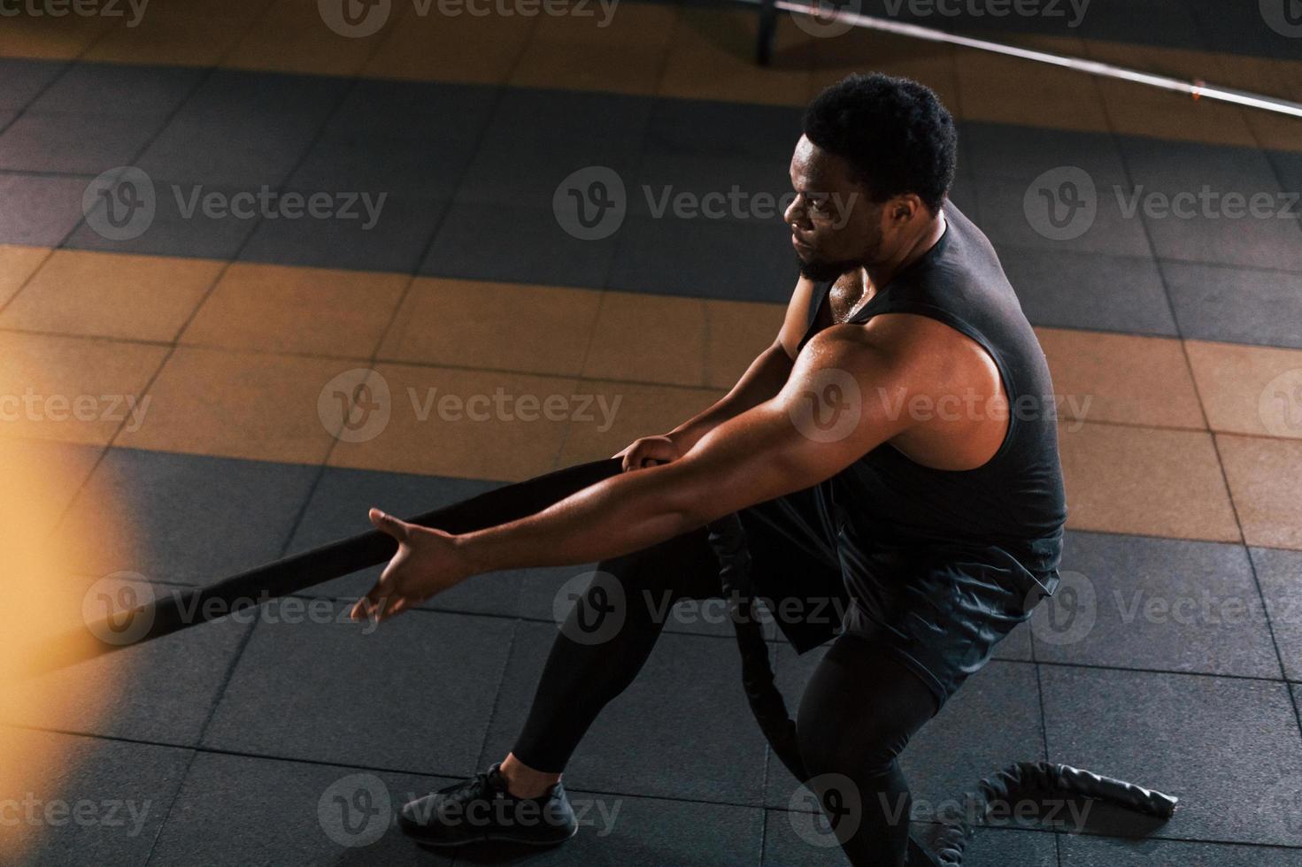 un hombre afroamericano con ropa deportiva tiene un día de entrenamiento en haciendo crossfit usando cuerdas 15293927 Foto de stock en Vecteezy