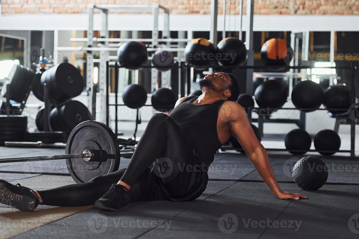 Strong african american man in sportive clothes have workout day in the gym photo
