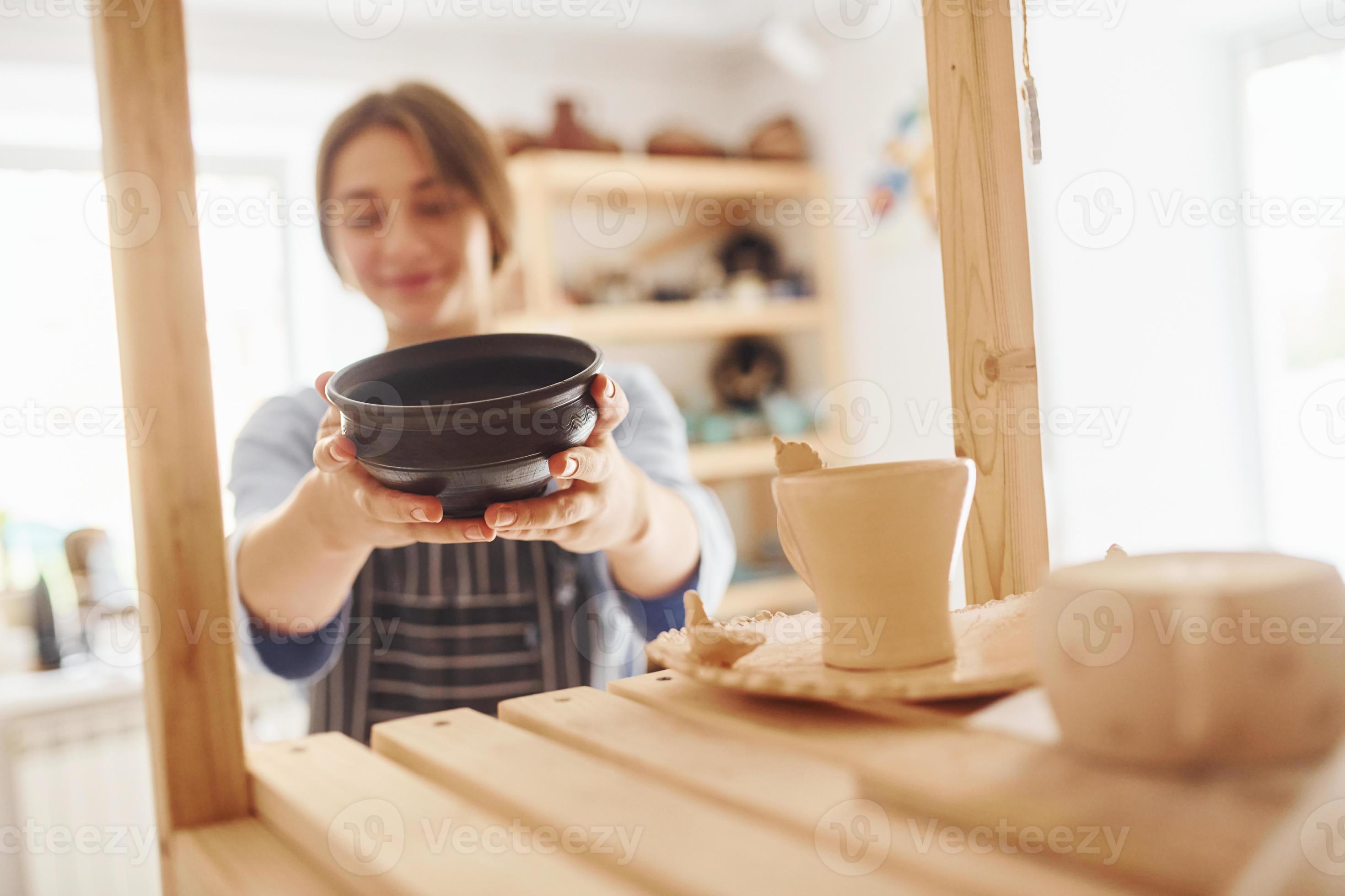 Job is done. Young female ceramist indoors with finished handmade clay