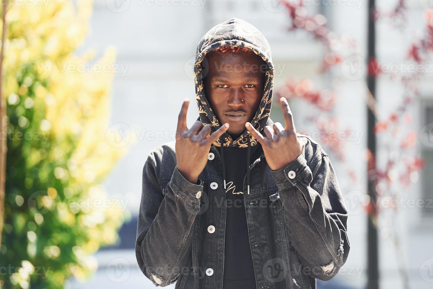 Young african american man in black jacket outdoors in the city photo