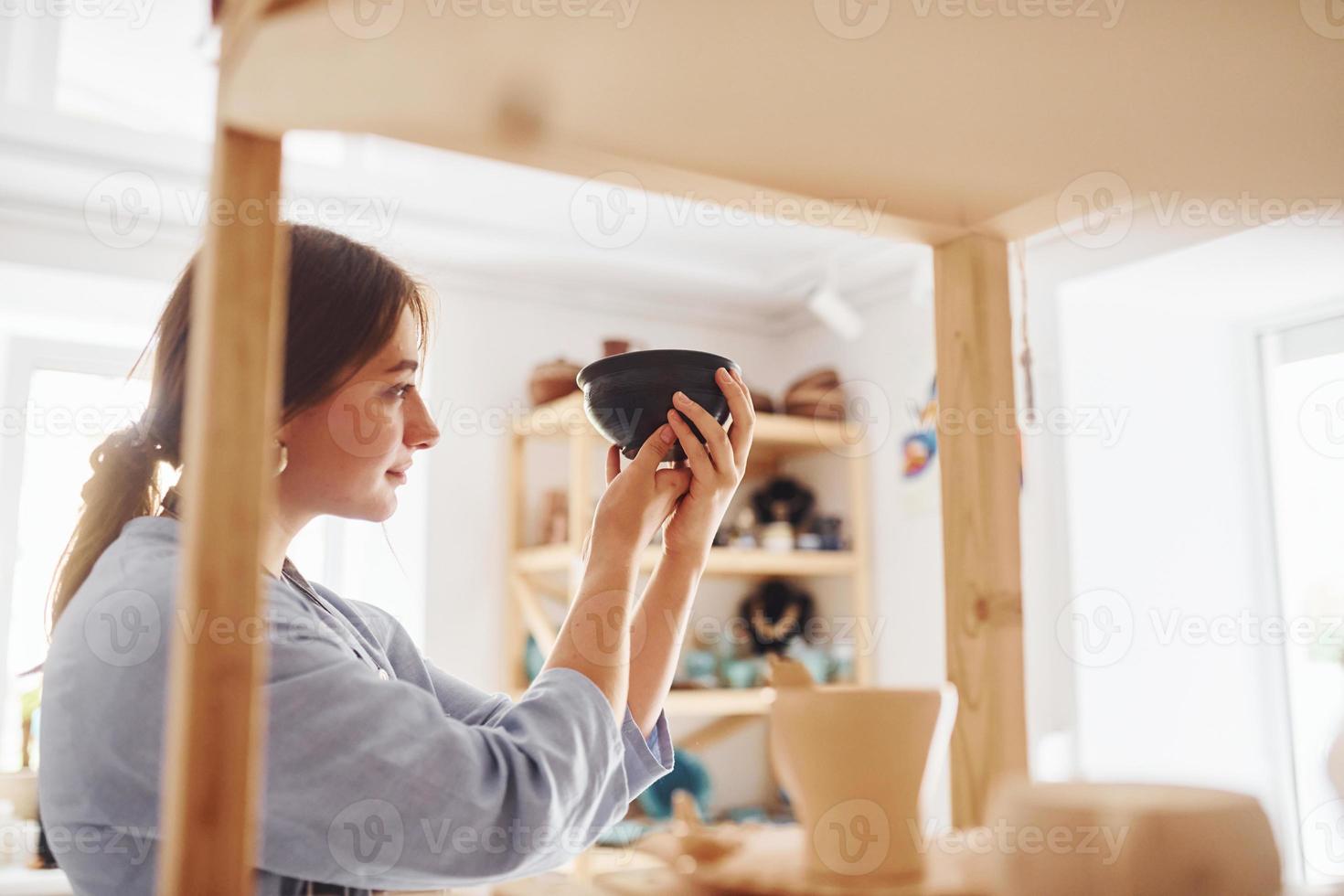 Job is done. Young female ceramist indoors with finished handmade clay