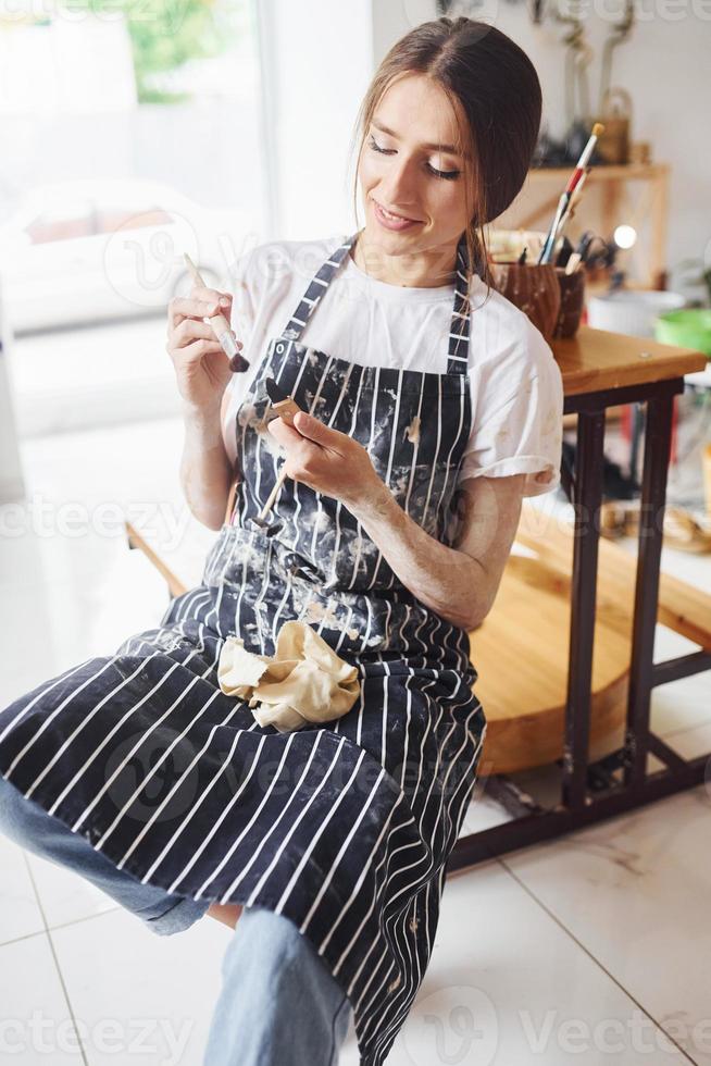 Young female ceramist indoors with handmade clay product. Conception of pottery photo