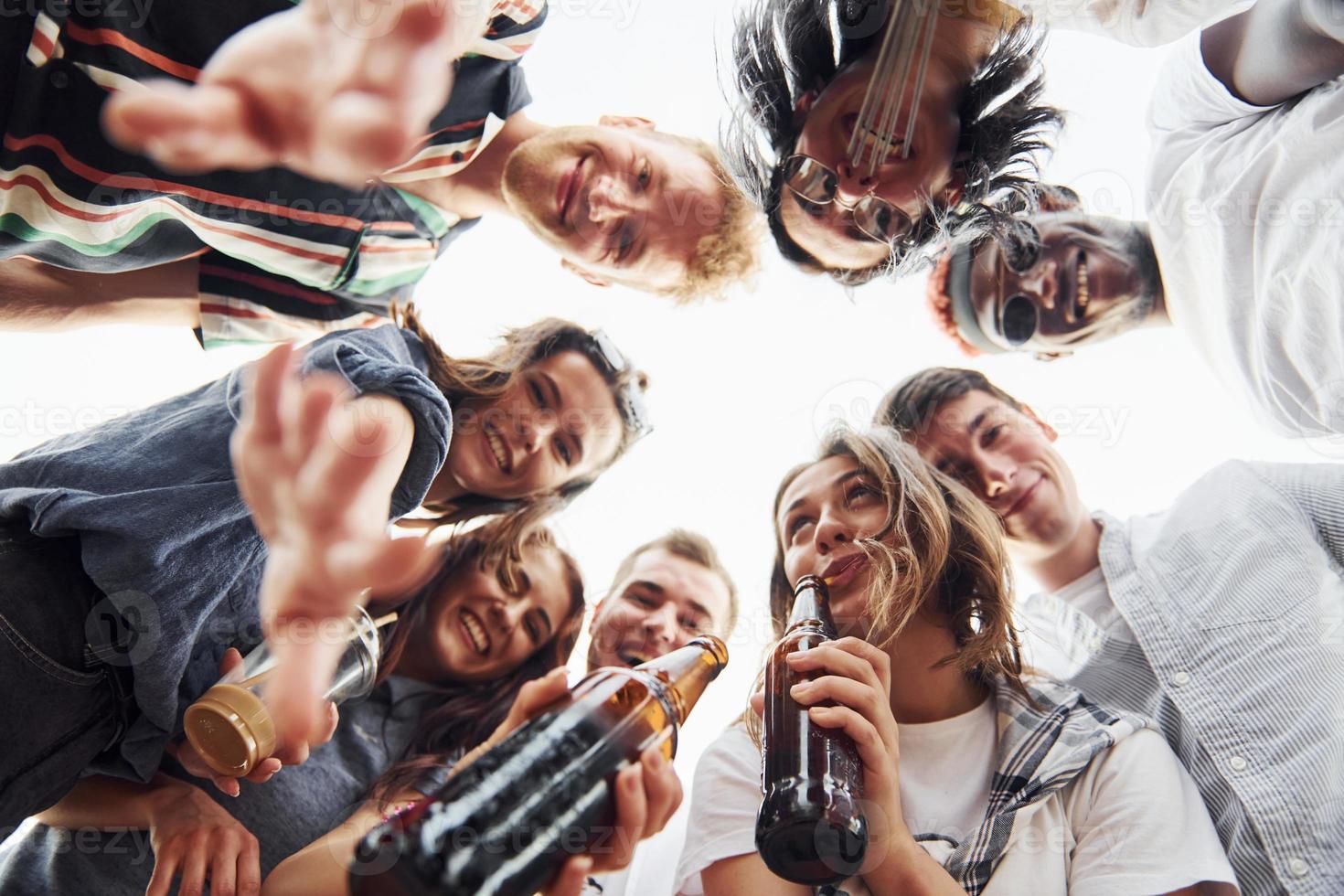 Looking down. View from below. Group of young people in casual clothes have a party at rooftop together at daytime photo