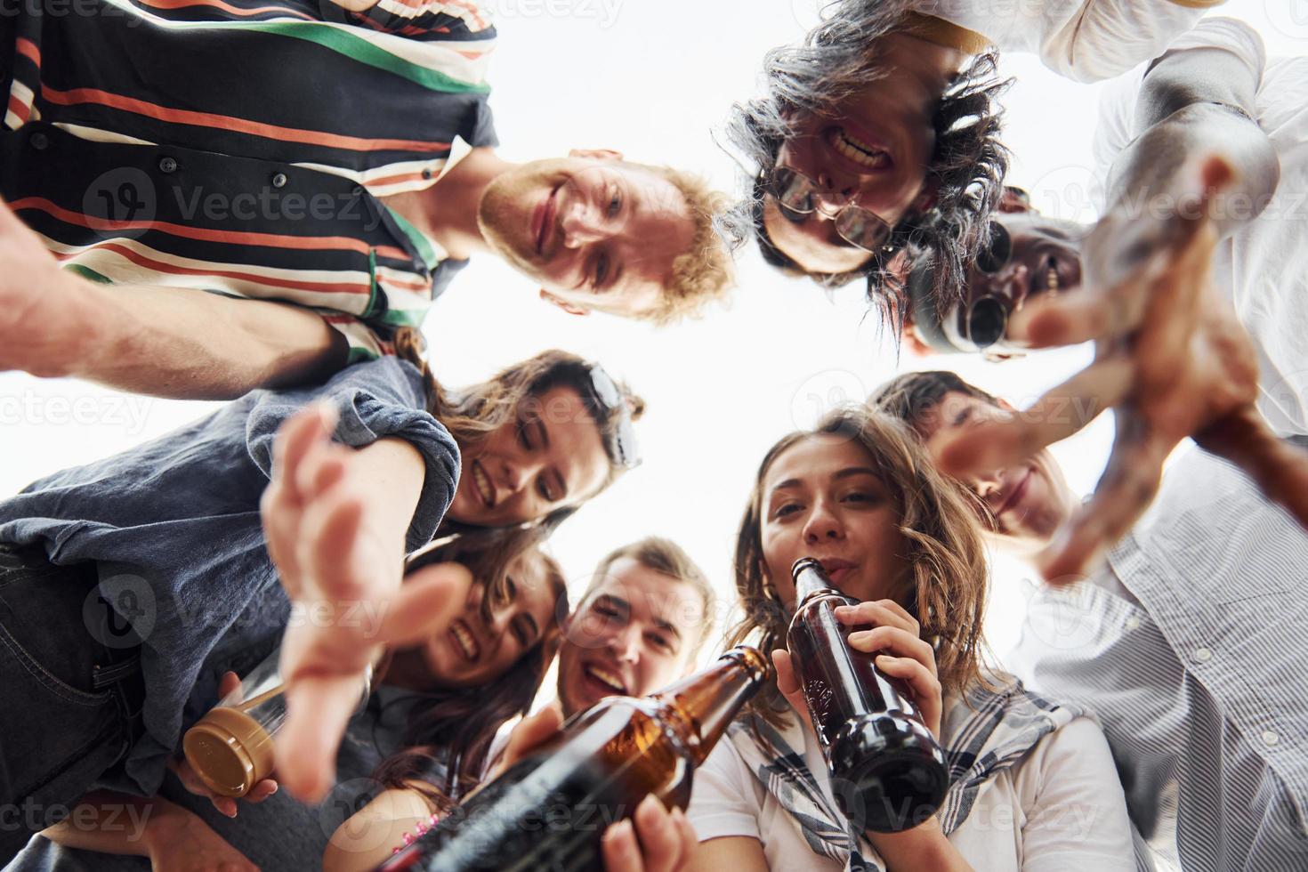 Looking down. View from below. Group of young people in casual clothes have a party at rooftop together at daytime photo