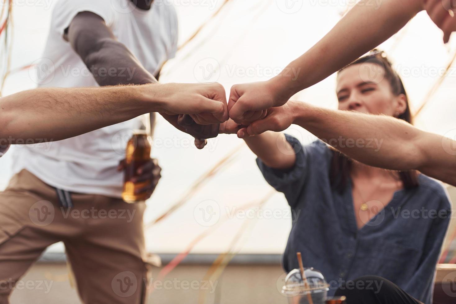 Unity of people. Group of young people in casual clothes have a party at rooftop together at daytime photo