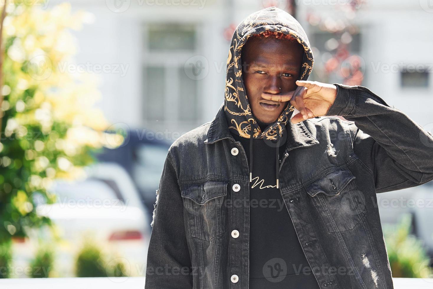 Young african american man in black jacket outdoors in the city photo