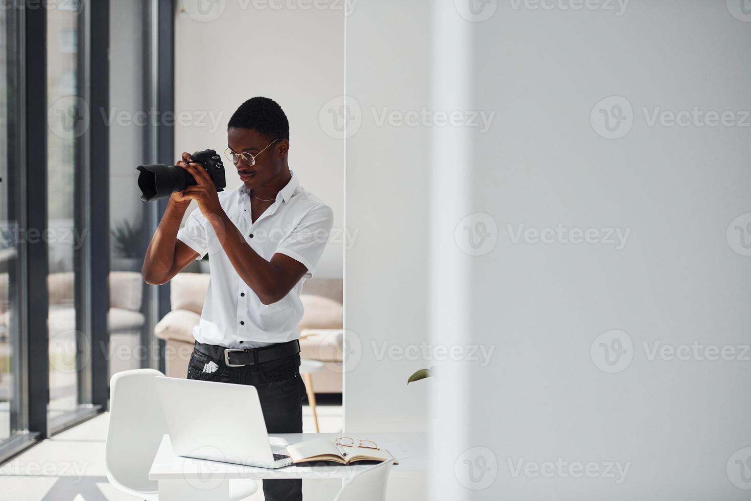 Testing camera. Young african american man in formal clothes is in the office photo