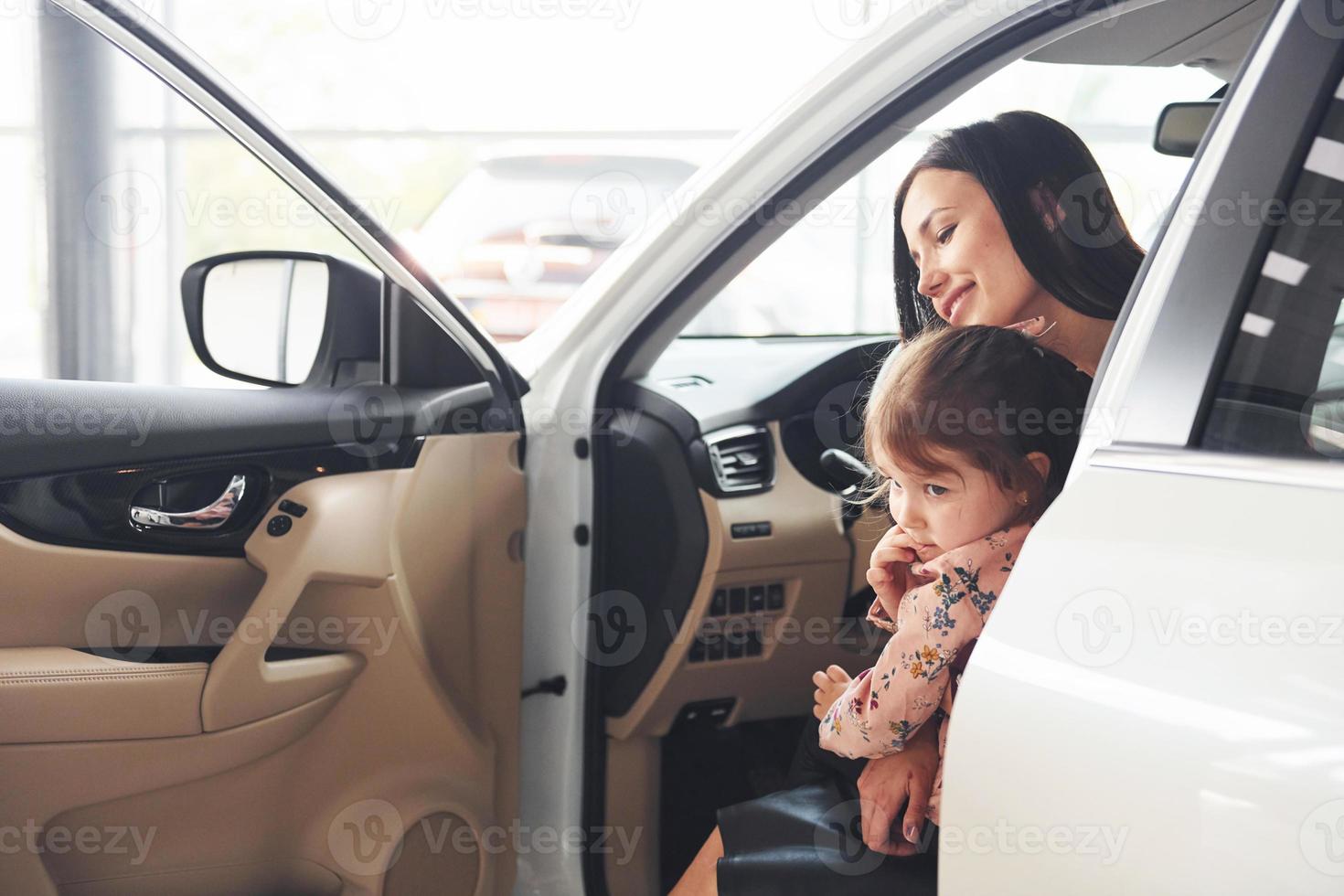 Mother with her daughter inside of modern automobile together photo