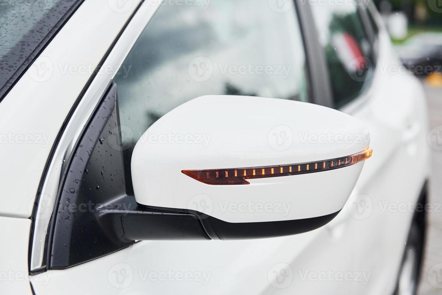 Front particle view of white modern automobile. Side mirror photo