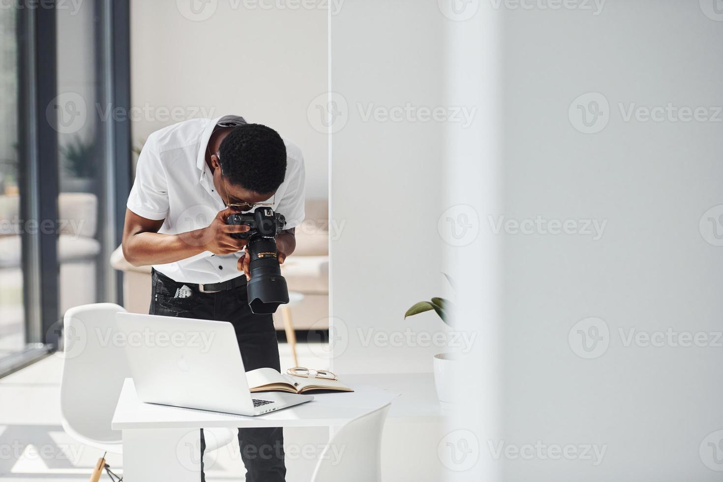 Testing camera. Young african american man in formal clothes is in the office photo