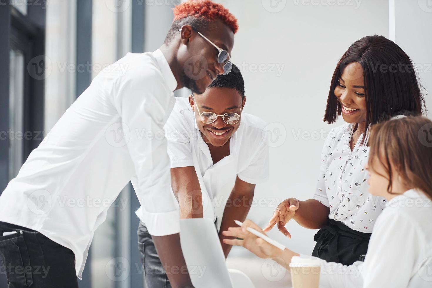 usando una computadora portátil grupo de empresarios afroamericanos que trabajan juntos en el cargo foto