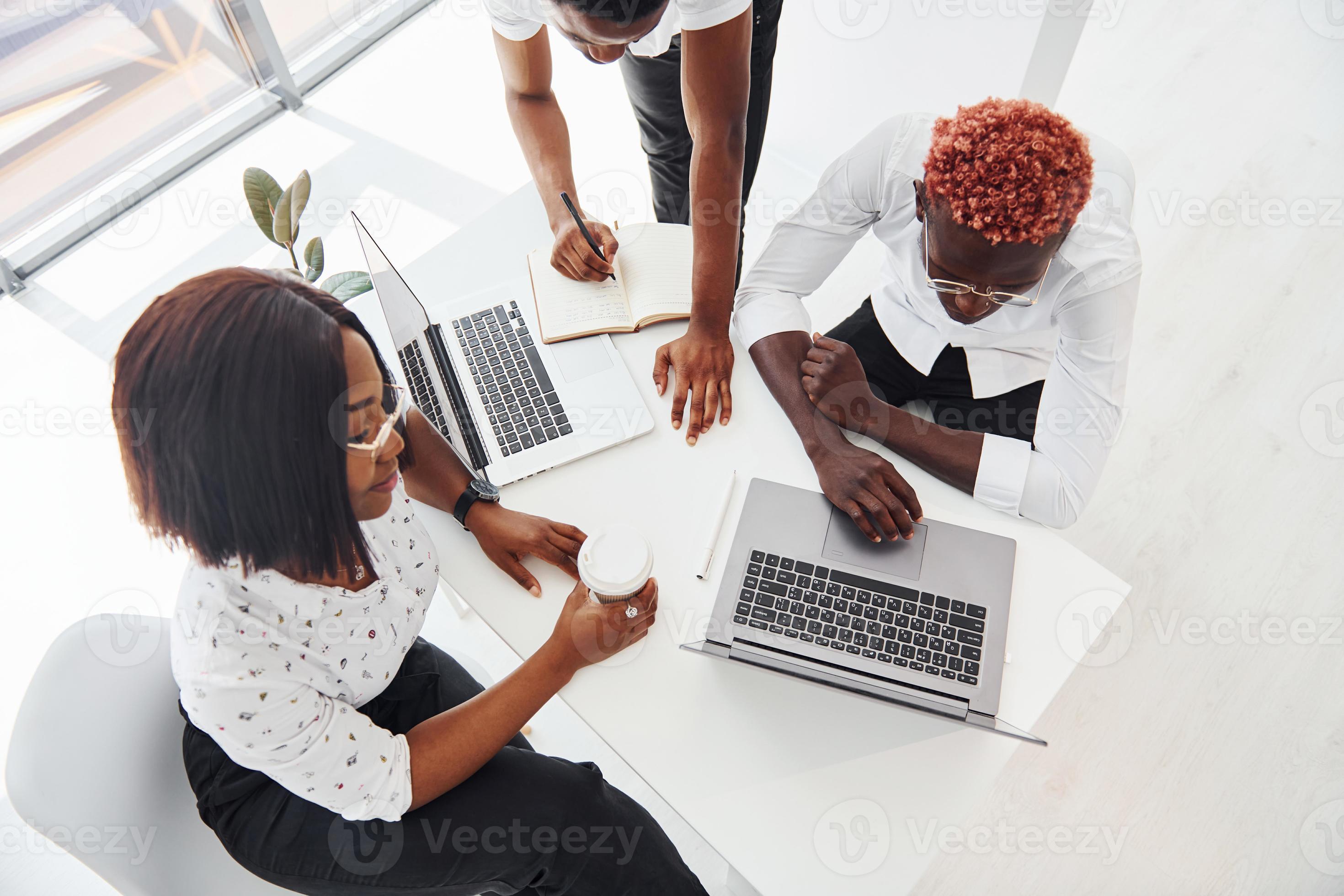 Concentrated at project by using laptop. Group of african american