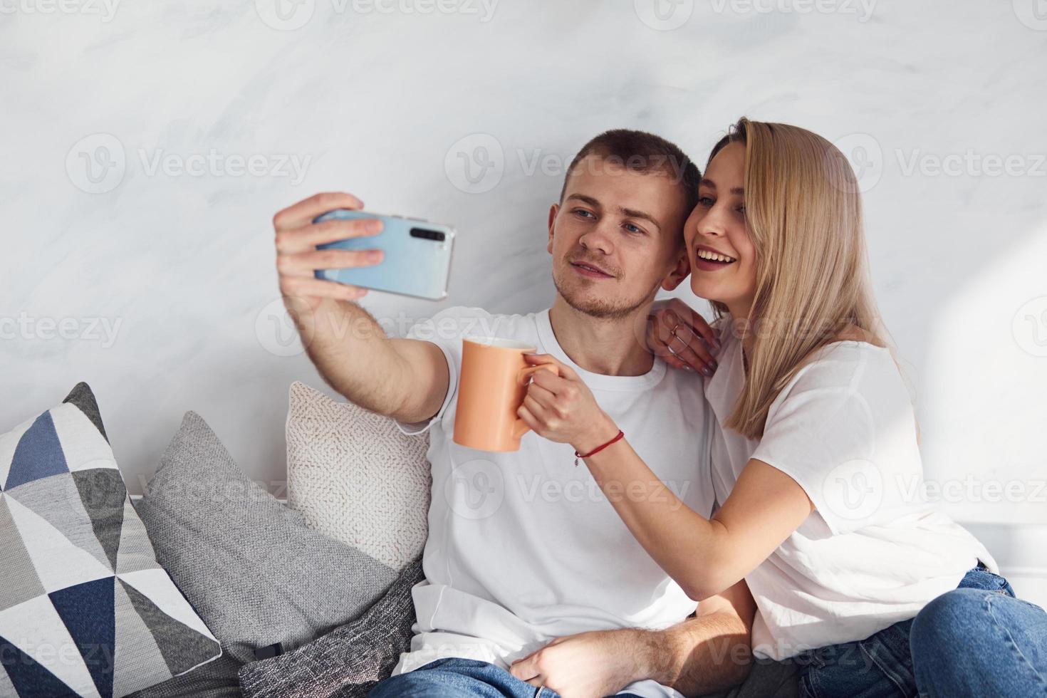 Man holding phone and making selfie of himself and his girlfriend photo