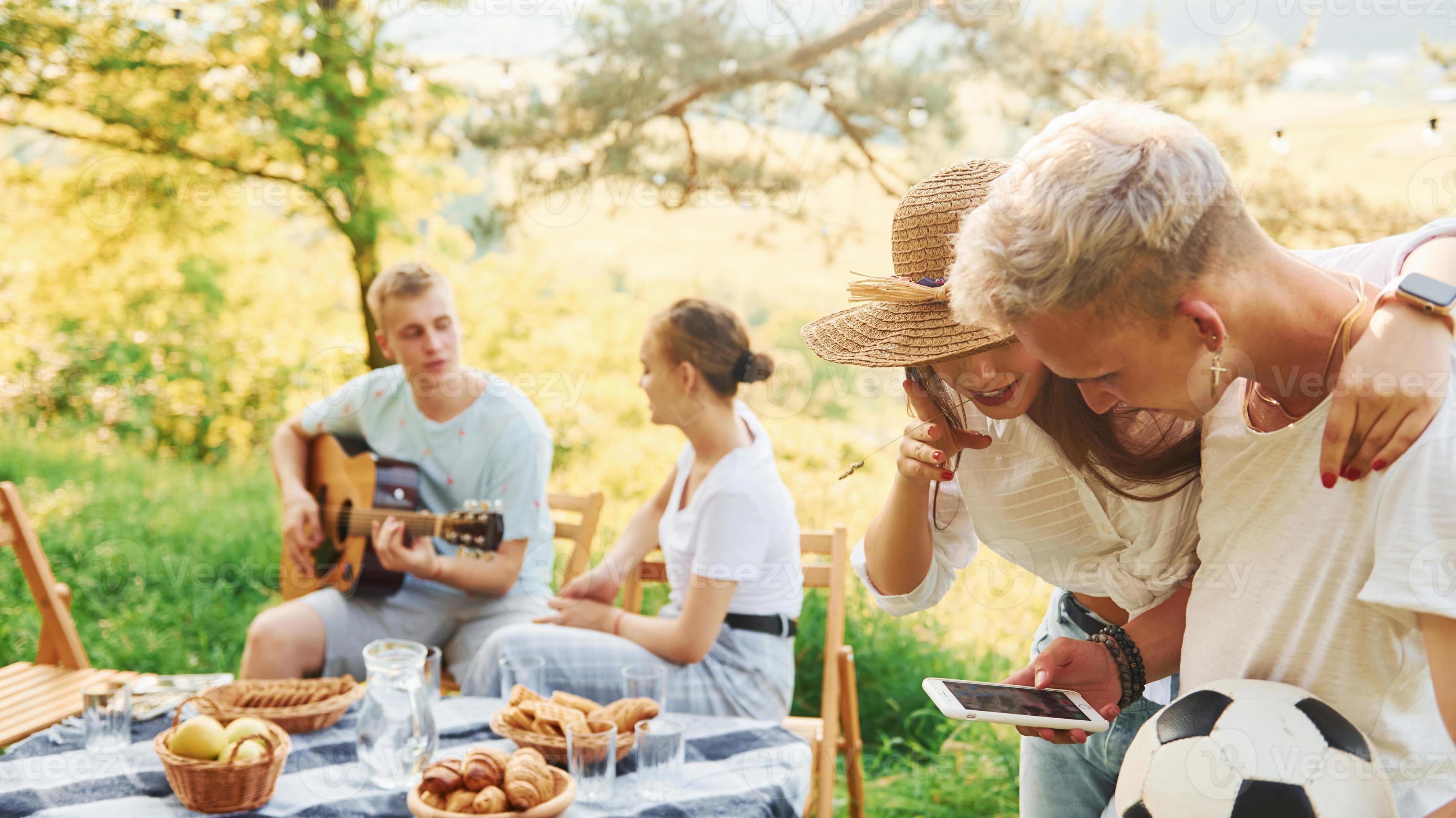 Man holding soccer ball. Group of young people have vacation outdoors