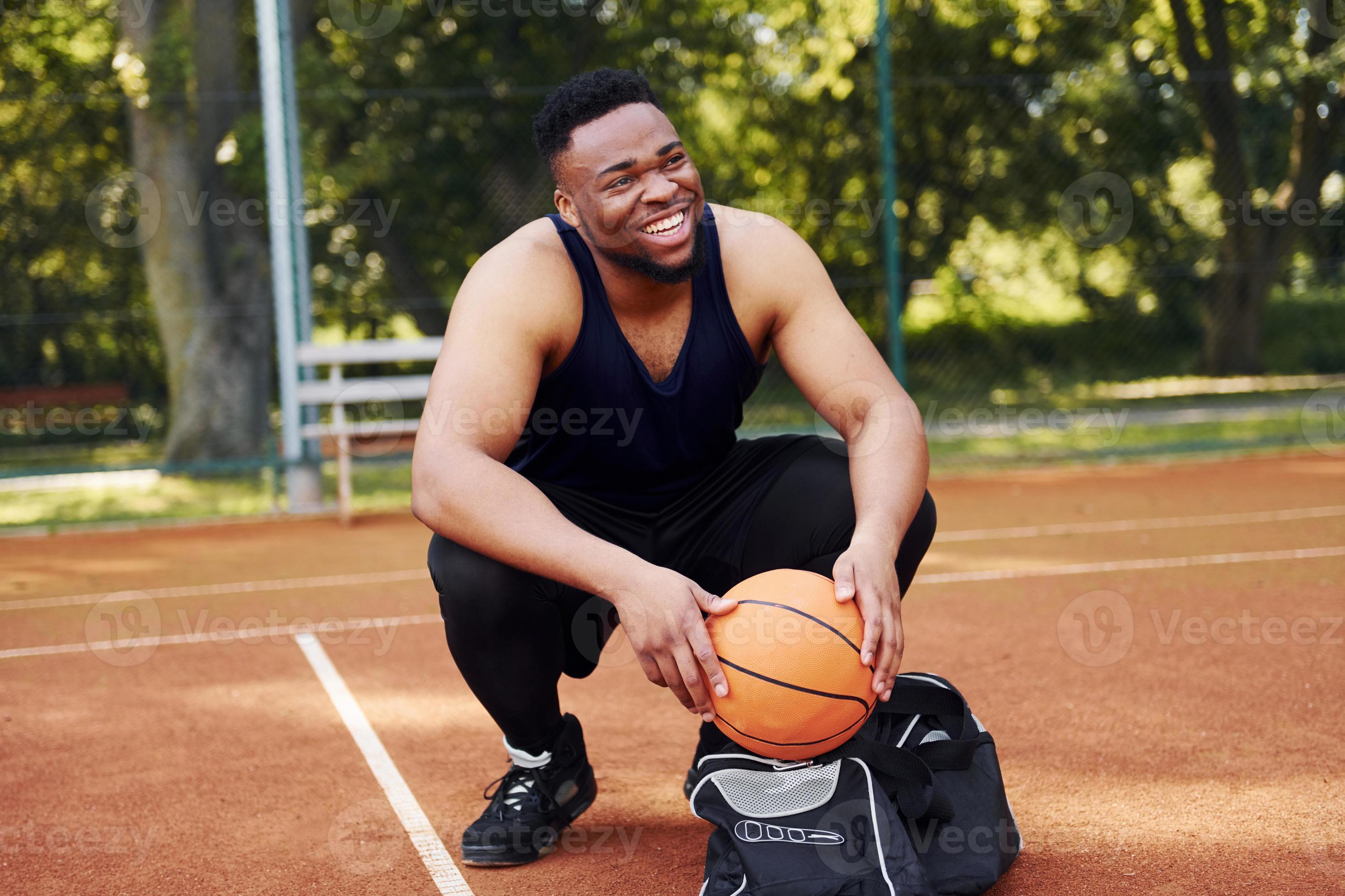 Sits with black bag and preparing for the game. African american man