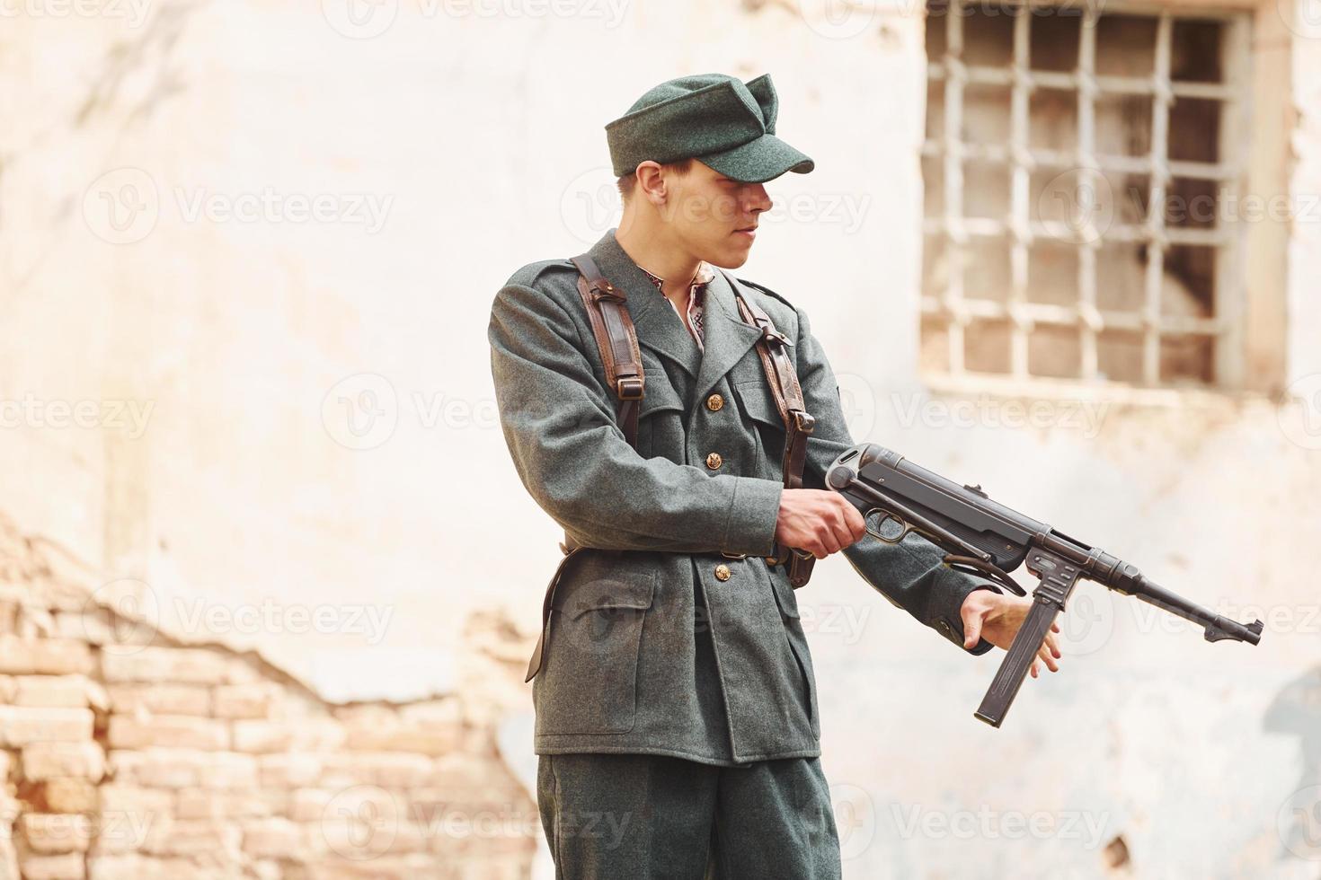 TERNOPIL, UKRAINE - June 2020 UPA Ukrainian Insurgent Army movie filming. Pictures of backstage. Young soldier with weapon near old building photo