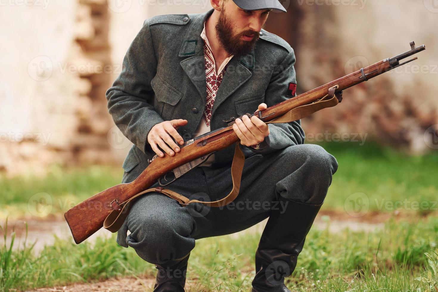 TERNOPIL, UKRAINE - June 2020 UPA Ukrainian Insurgent Army movie filming. Pictures of backstage. Young soldier with weapon near old building photo