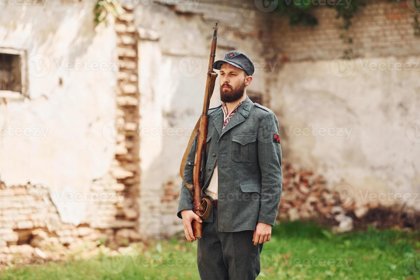 TERNOPIL, UKRAINE - June 2020 UPA Ukrainian Insurgent Army movie filming. Pictures of backstage. Young soldier with weapon near old building photo