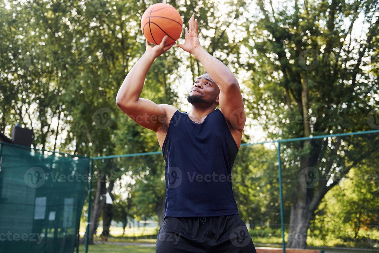 African american man plays basketball on the court outdoors photo