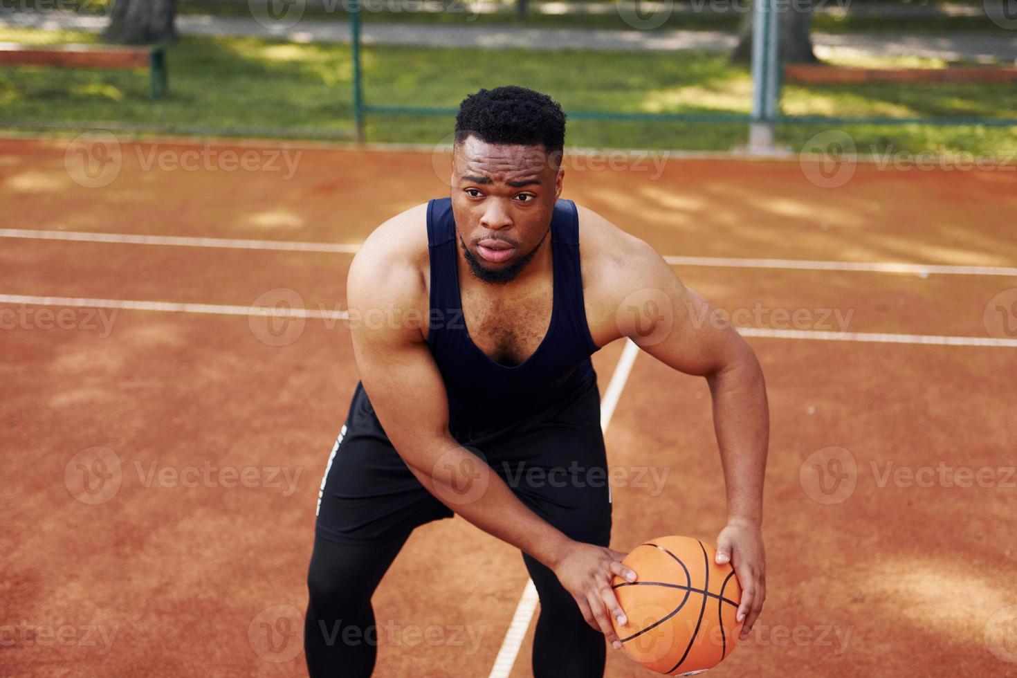 African american man plays basketball on the court outdoors photo