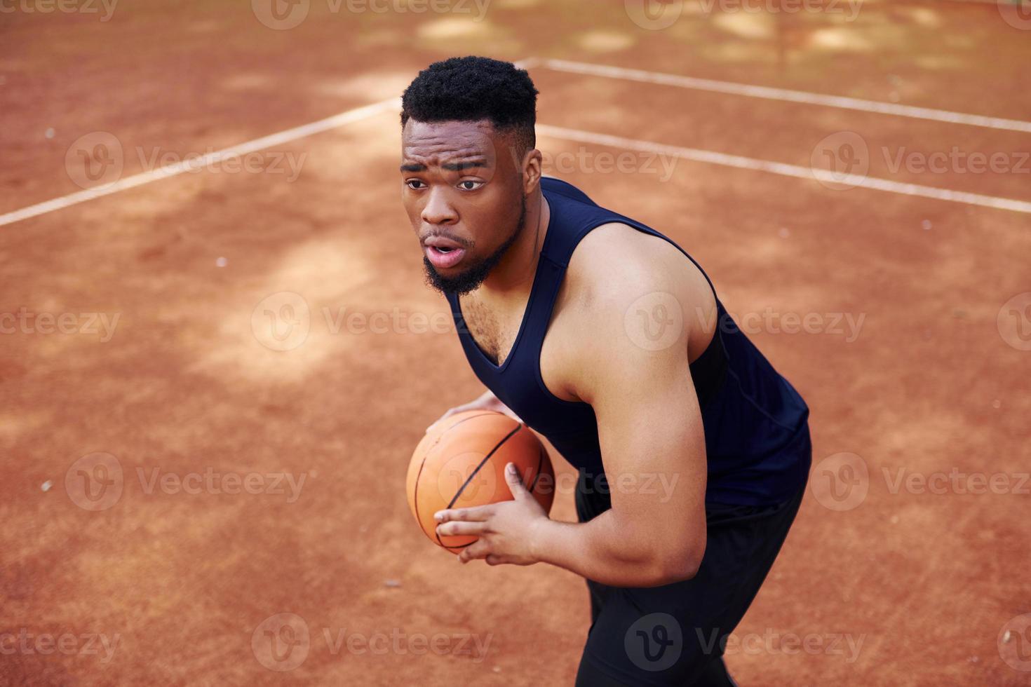 African american man plays basketball on the court outdoors photo