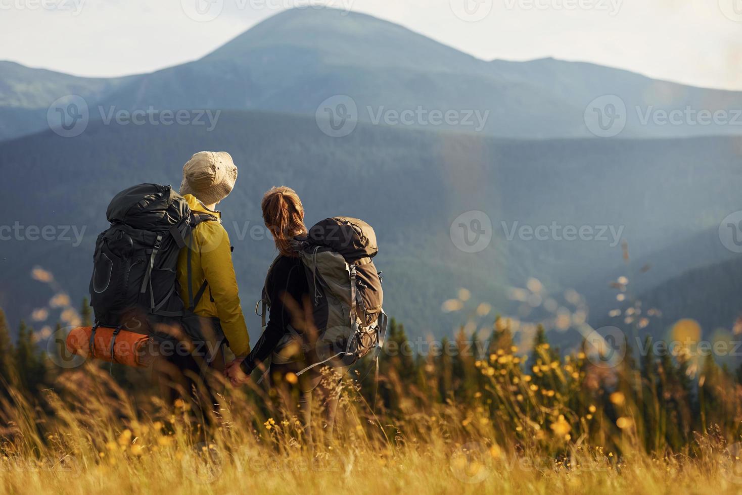Beautiful young people travel together. Majestic Carpathian Mountains. Beautiful landscape of untouched nature photo