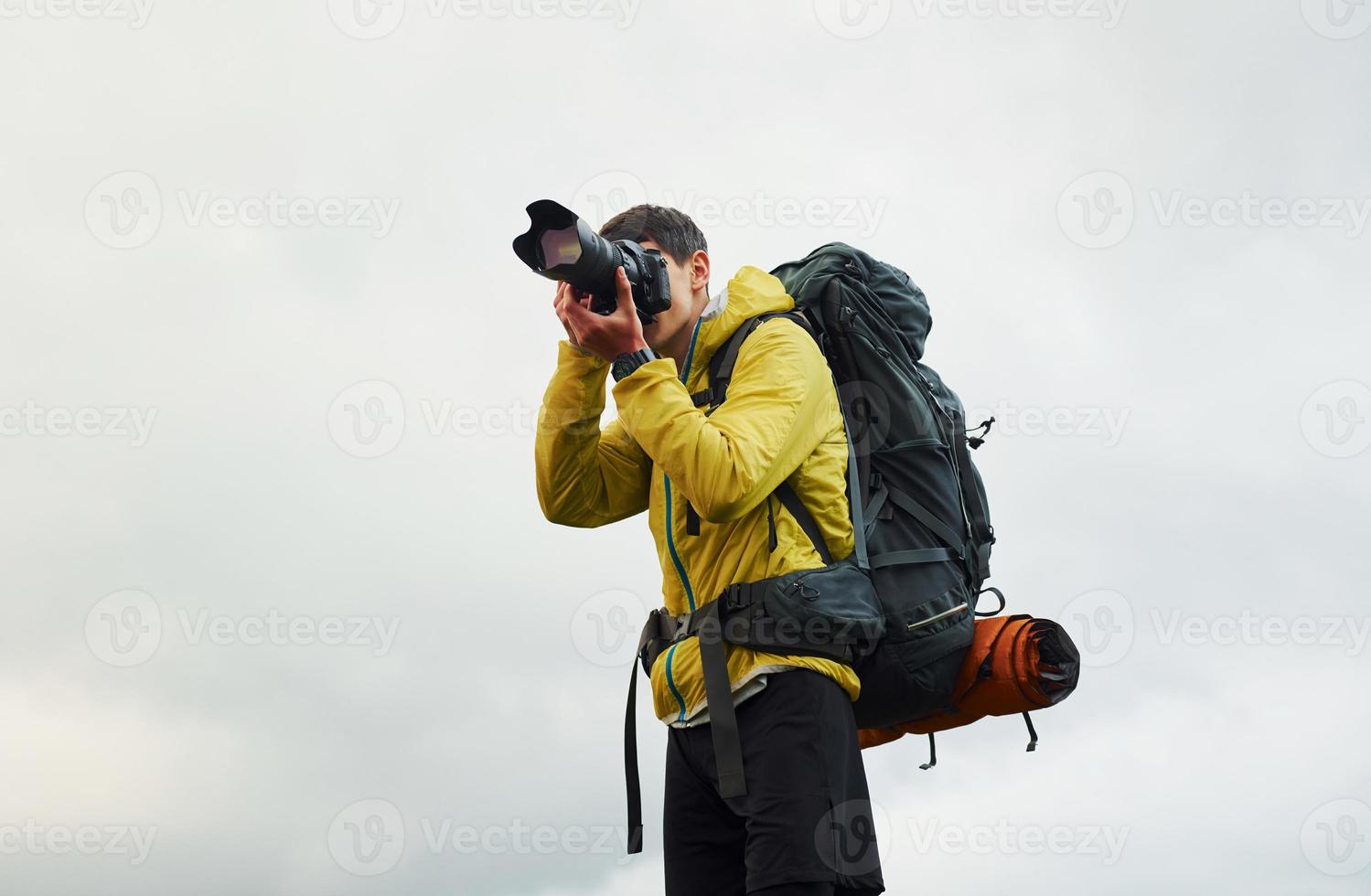 Young male photographer with his professional camera taking pictures of beautiful nature photo