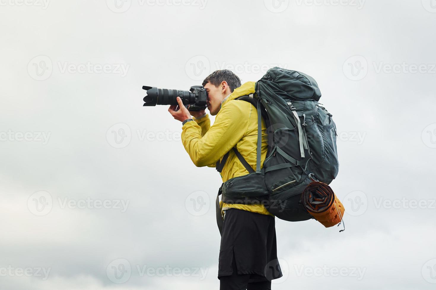 Young male photographer with his professional camera taking pictures of beautiful nature photo