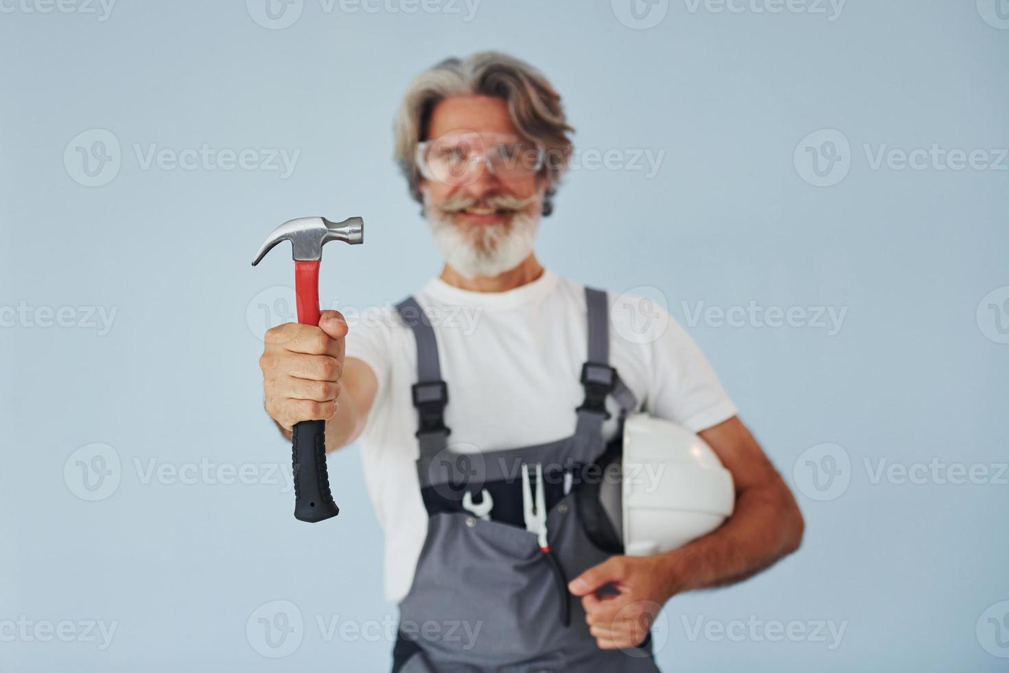 Repairman ready for work. Senior stylish modern man with grey hair and beard indoors photo