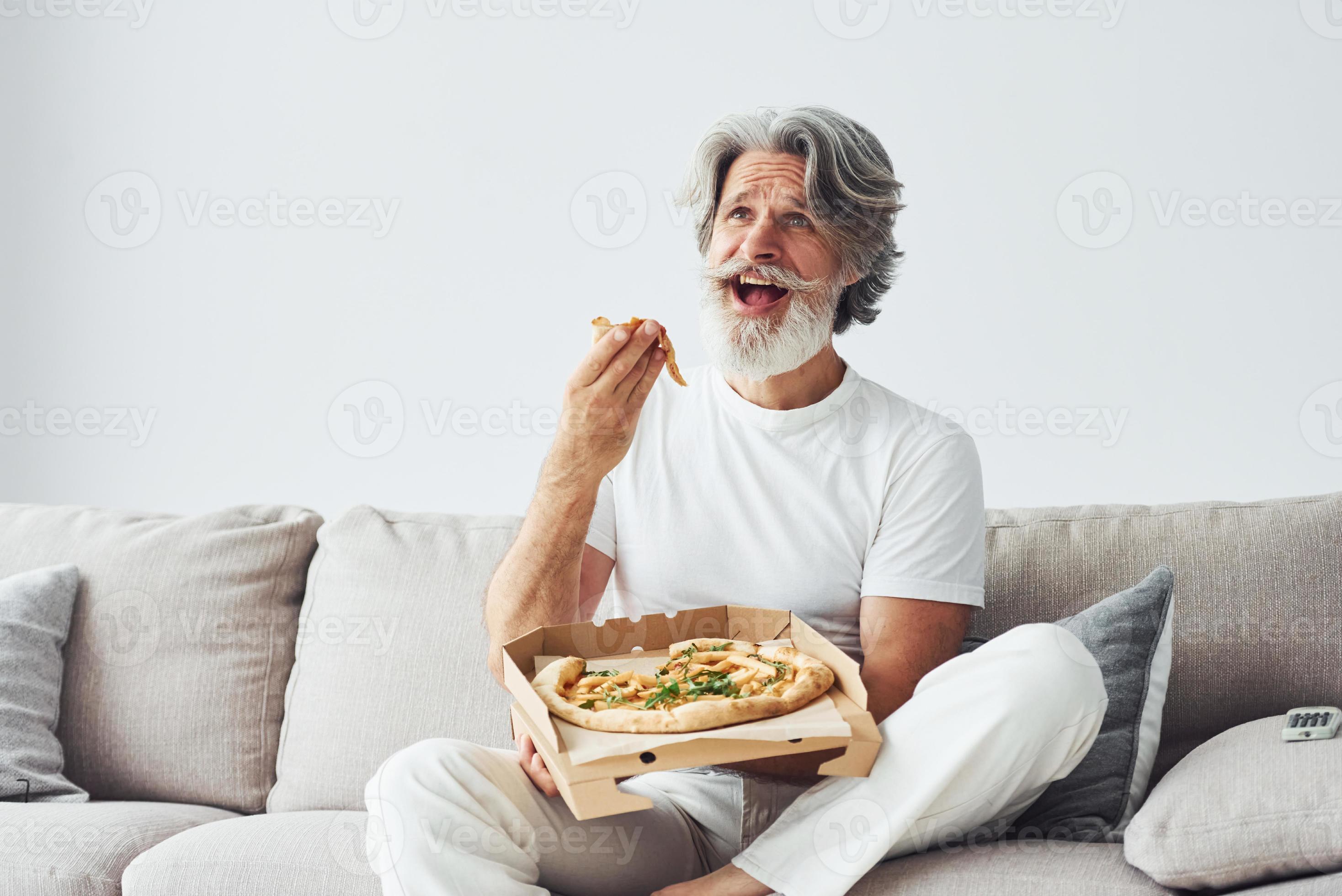 With delicious pizza. Watches TV show. Senior stylish modern man with grey hair and beard indoors 15299018 Stock Photo at Vecteezy With delicious pizza. Watches TV show. Senior stylish modern man with grey hair and beard indoors 15299018 Stock Photo at Vecteezy