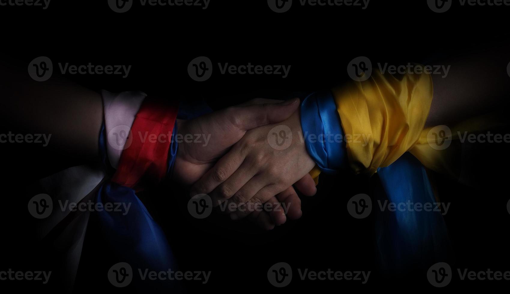 Russian flag and Ukraine flag in hands showing symbol of struggle war photo