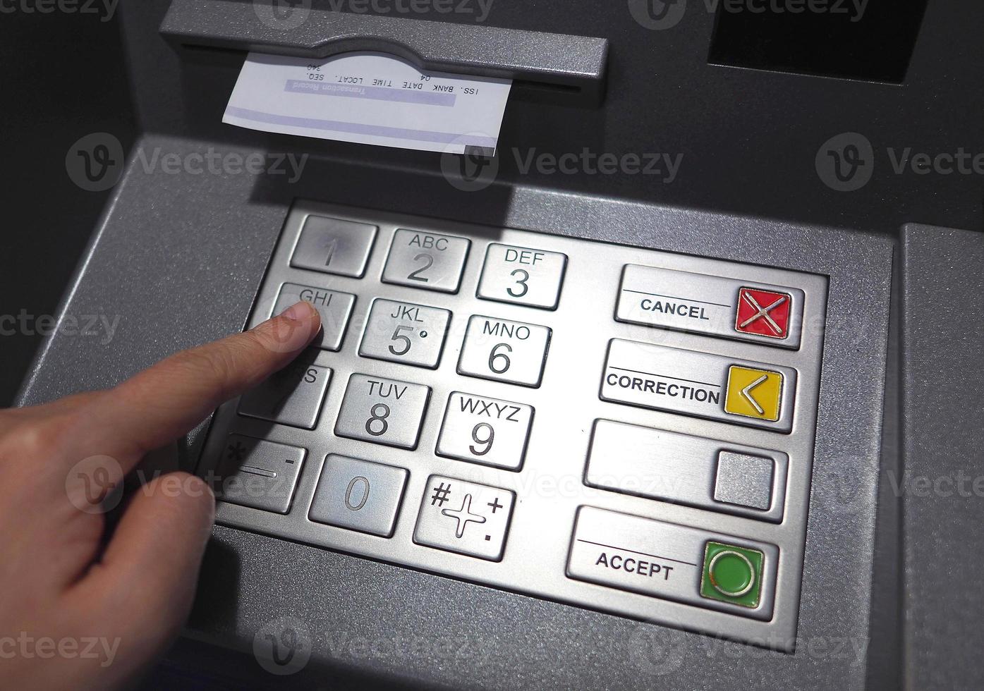 ATM button close up and paper transaction deposit pay slip and hand. photo