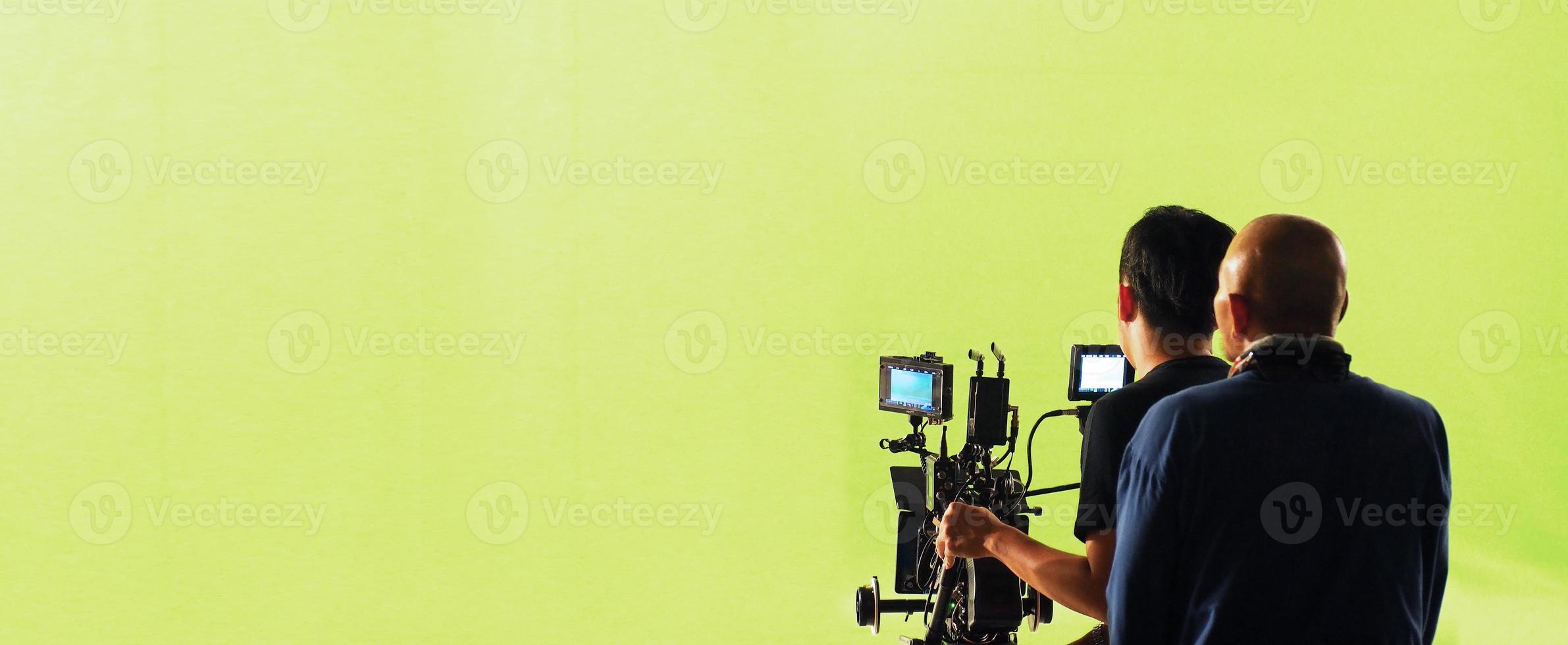 Camera and green screen studio in panorama view and man working or shooting or recording or filming. photo
