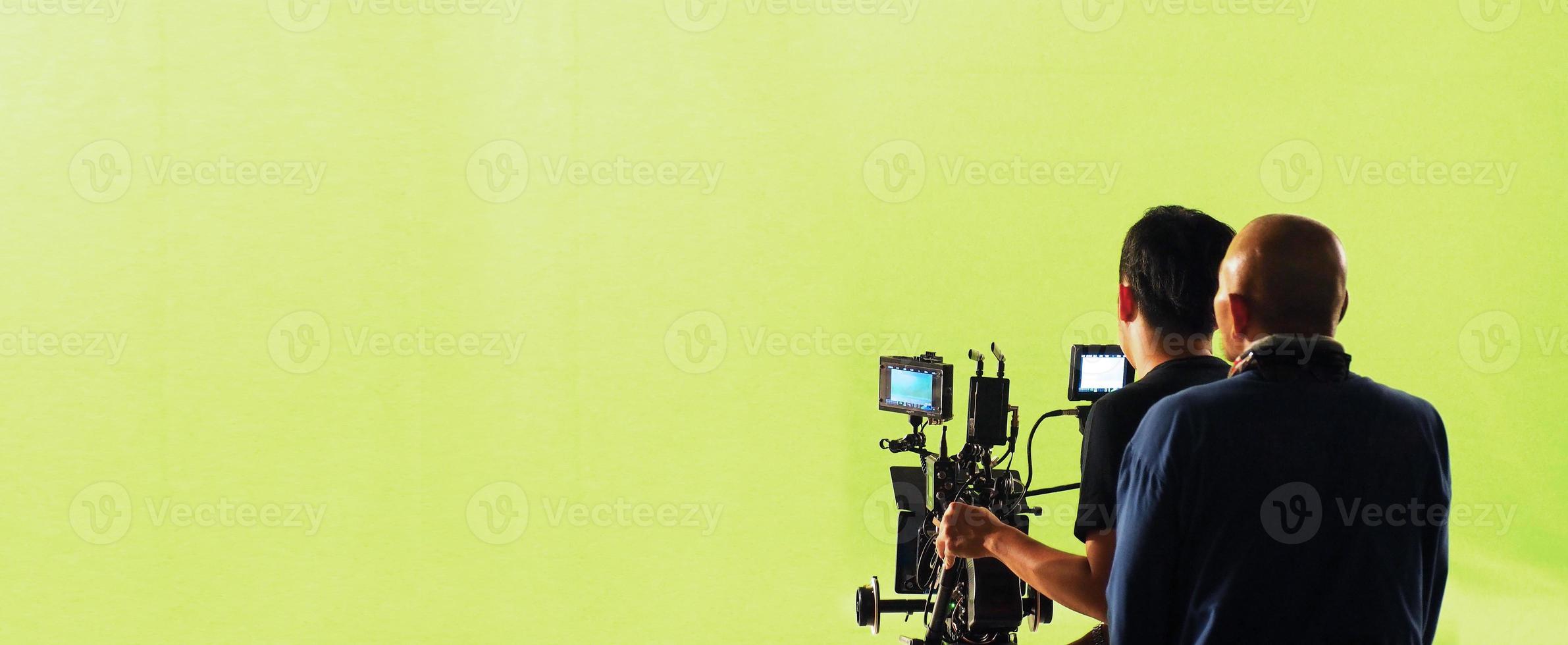 cámara y estudio de pantalla verde en vista panorámica y hombre trabajando o disparando o grabando o filmando. foto