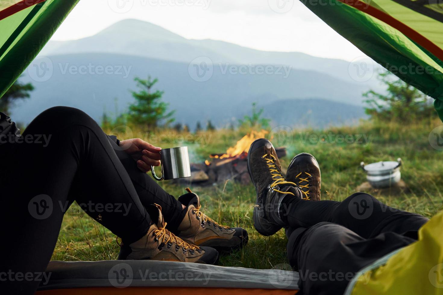 Man and woman inside of tent together. Majestic Carpathian Mountains. Beautiful landscape of untouched nature photo