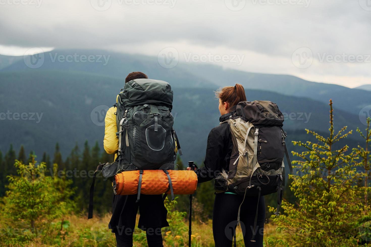 View from behind of young travelers. Majestic Carpathian Mountains. Beautiful landscape of untouched nature photo