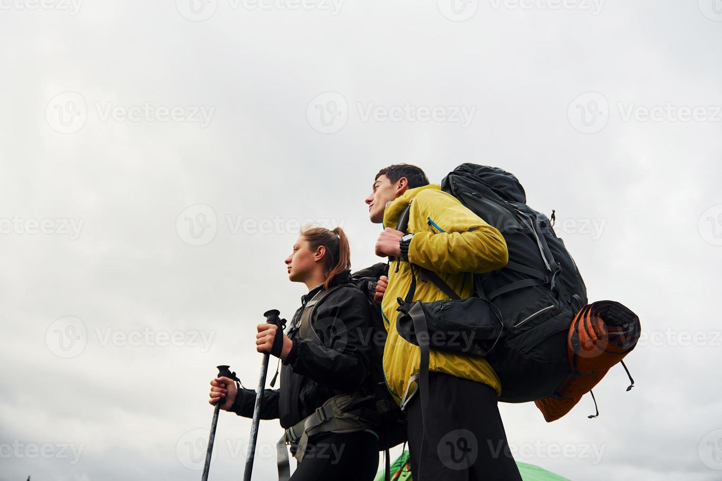 Young couple hiking outdoors together. Cloudy weather photo