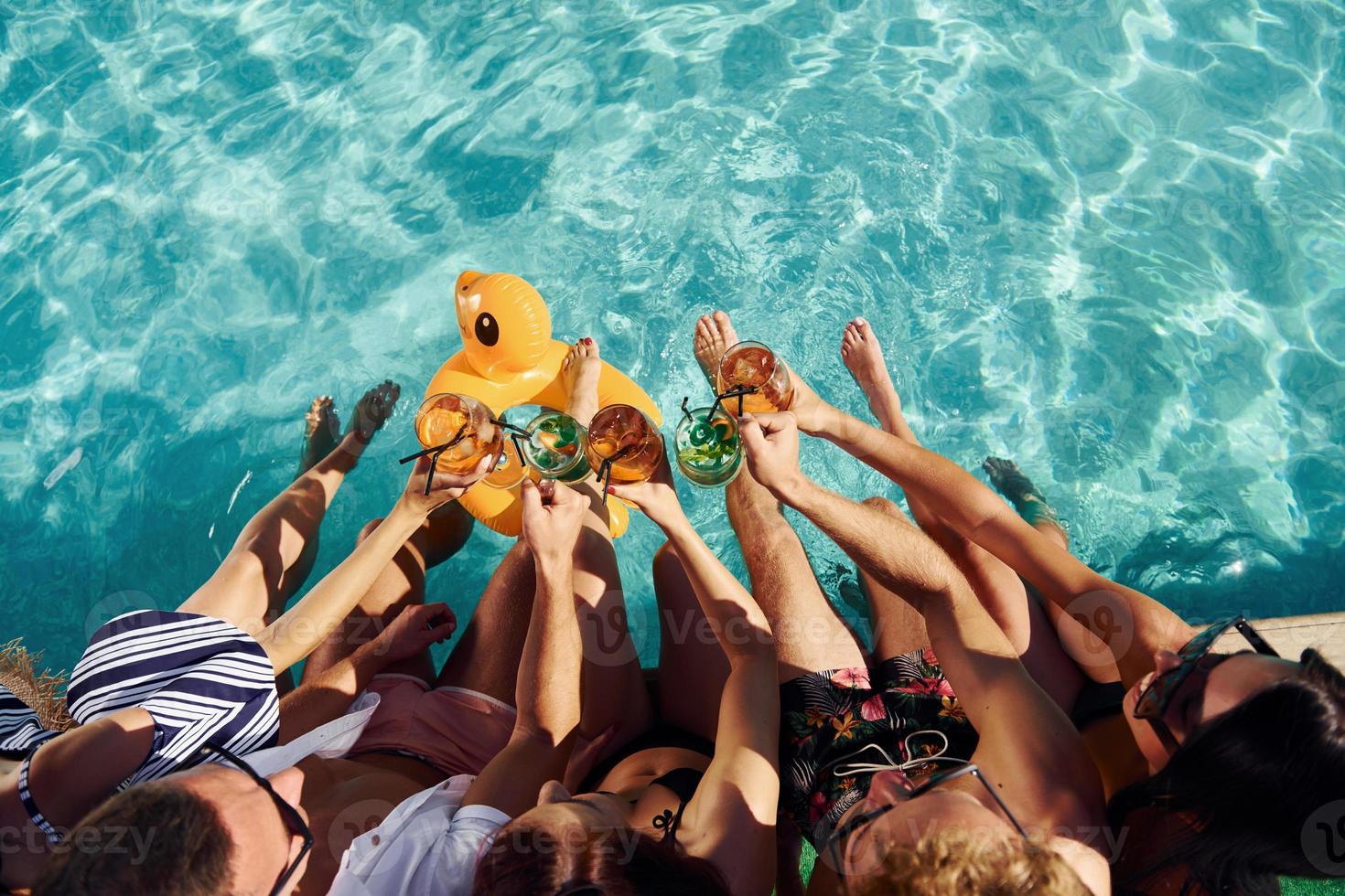 Top view of group of young happy people that have fun in swimming pool at daytime photo