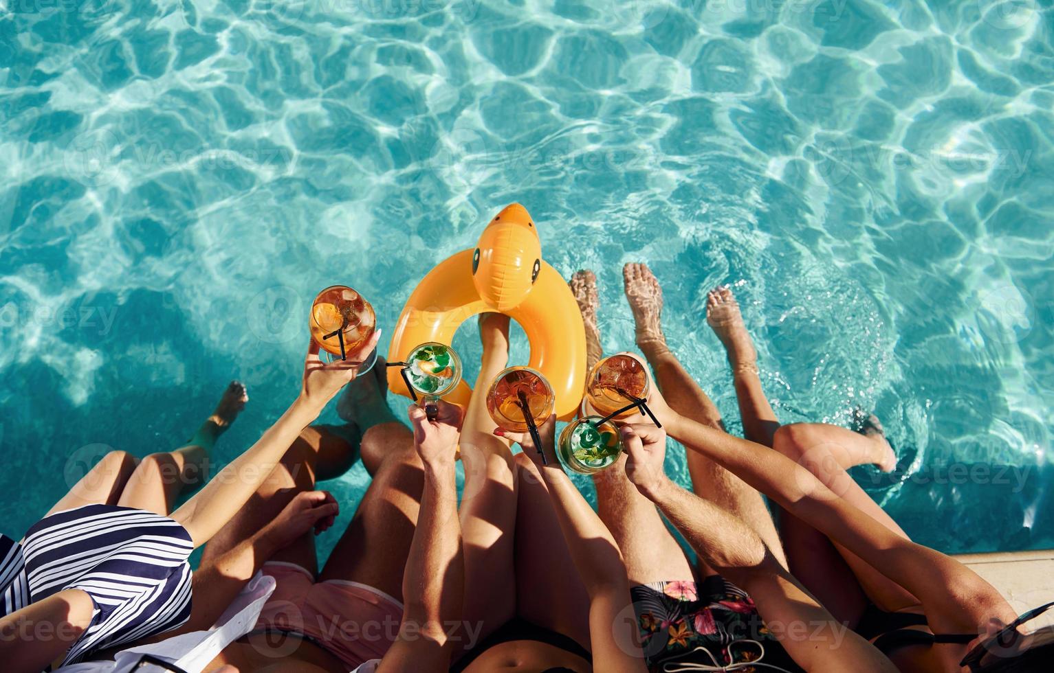 Top view of group of young happy people that have fun in swimming pool at daytime photo