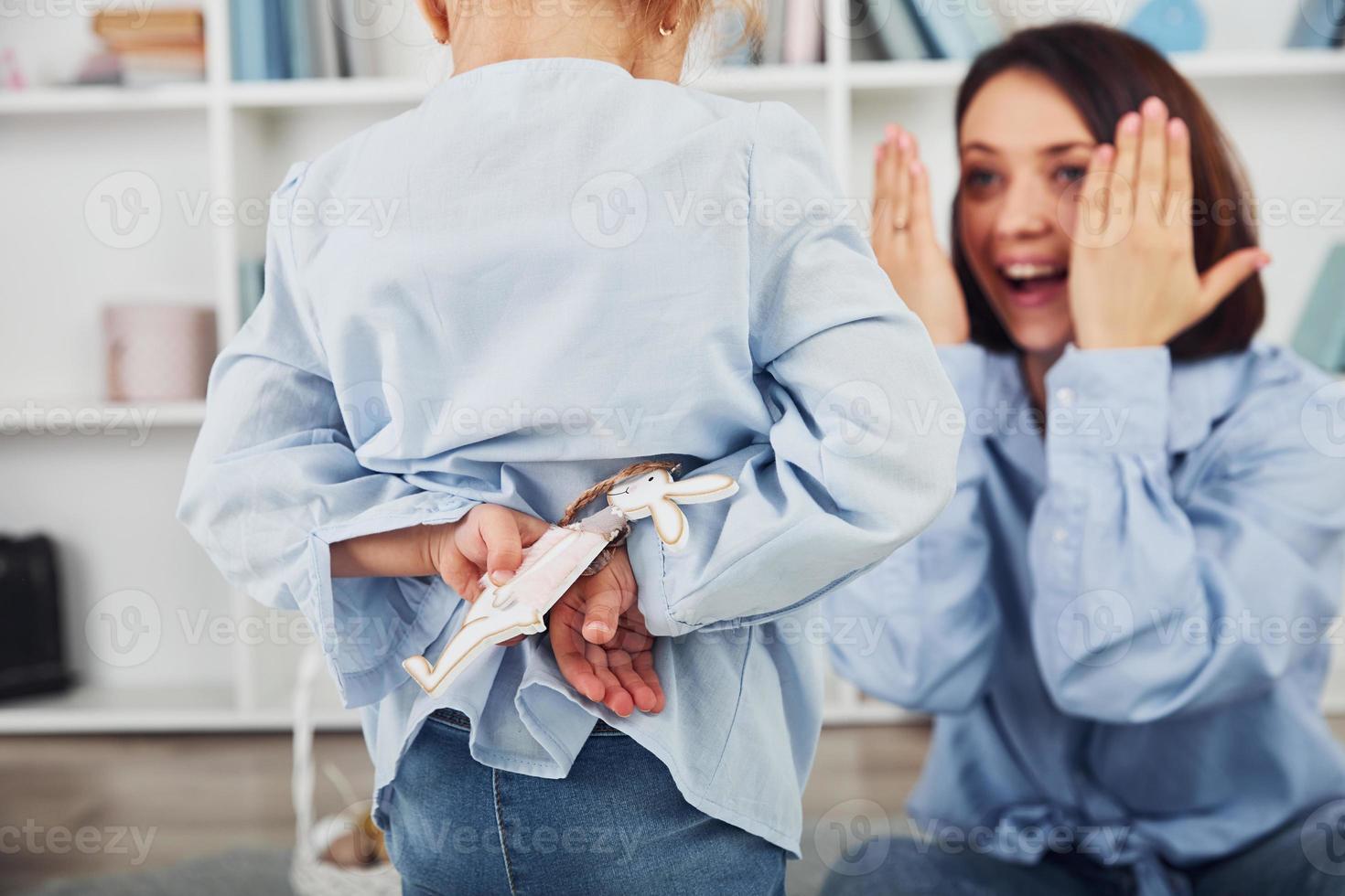 Little girl makes surprise for mother and giving her handmaded bunny photo