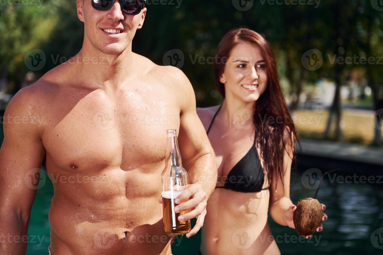 Positive people. Cheerful couple or friends together in swimming pool at vacation photo